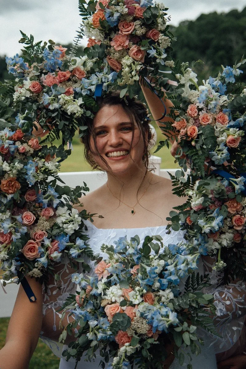 Bride framed by an abundant arrangement of blue, peach, and white flowers