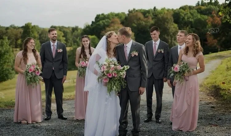 Wedding party carrying coordinated pink rose bouquets and boutonnieres